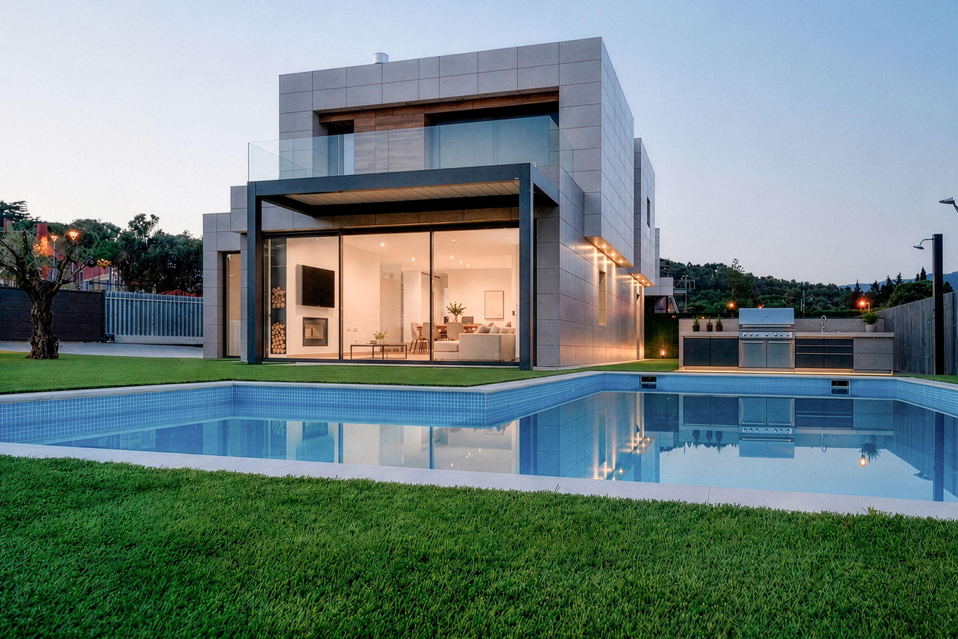 Fachada al jardín de MP13 al atardecer con piscina iluminada