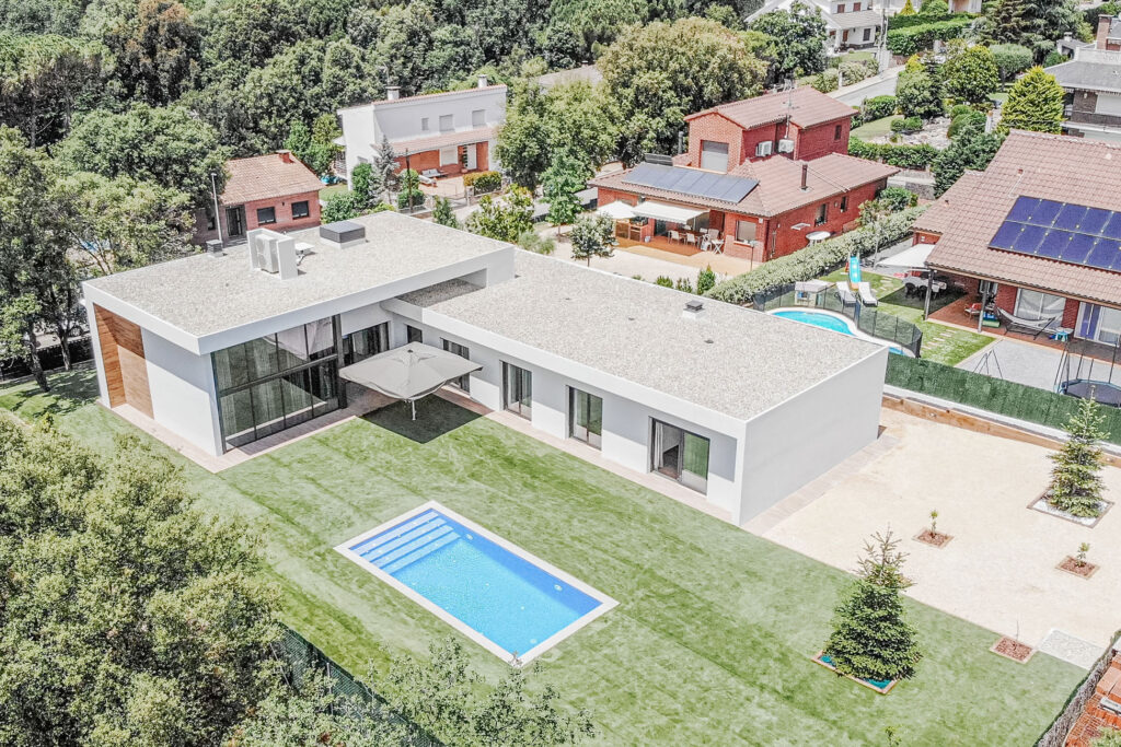 Vista aérea de casa unifamiliar en L con jardín y piscina en l’Ametlla del Vallès