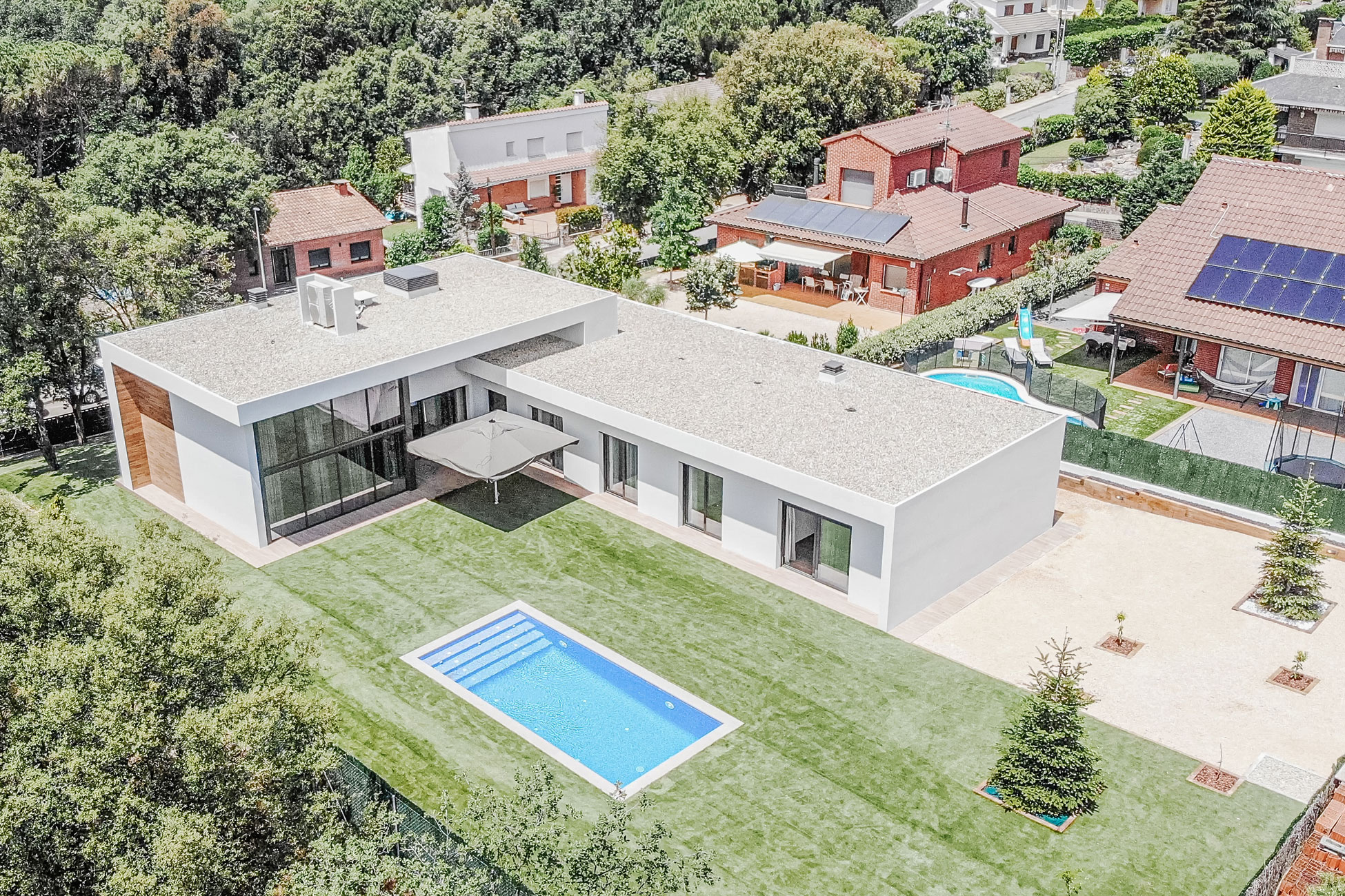 Vista aérea de casa unifamiliar en L con jardín y piscina en l’Ametlla del Vallès