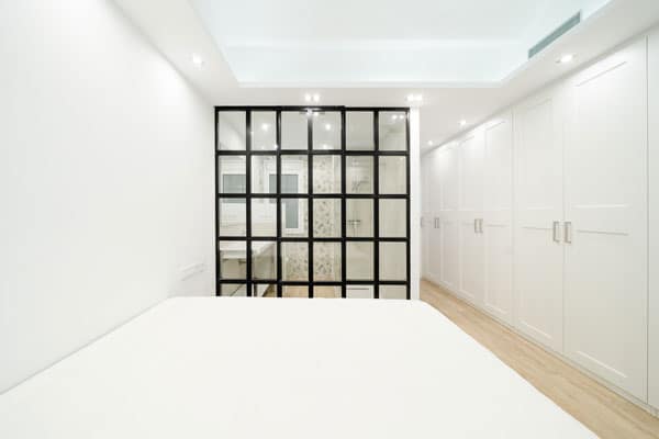 Habitación en suite con vidriera de hierro en reforma integral con afectación estructural en Barcelona