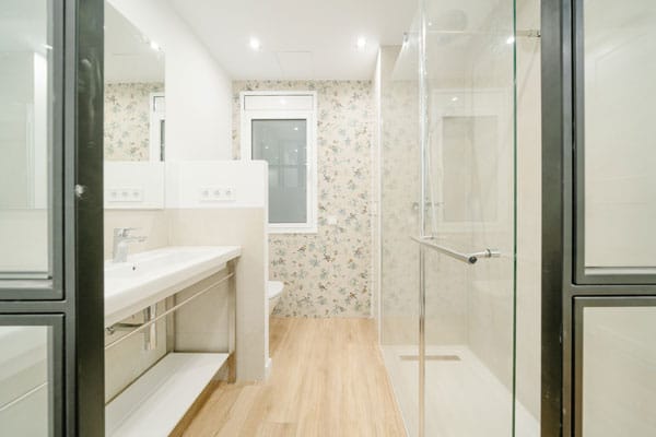 Lavabo en suite con baldosas de pájaros en reforma integral con afectación estructural en Barcelona