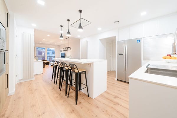 Antes-después Cocina con isla en reforma integral con domótica en Barcelona
