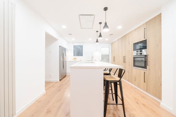 Antes-después Cocina con isla en reforma integral con domótica en Barcelona