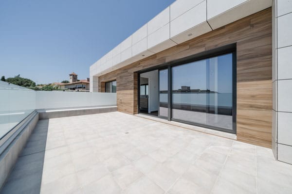 Terraza con fachada ventilada y barandilla de vidrio
