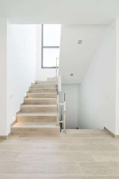 Escalera con barandillas de cristal en vivienda unifamiliar moderna