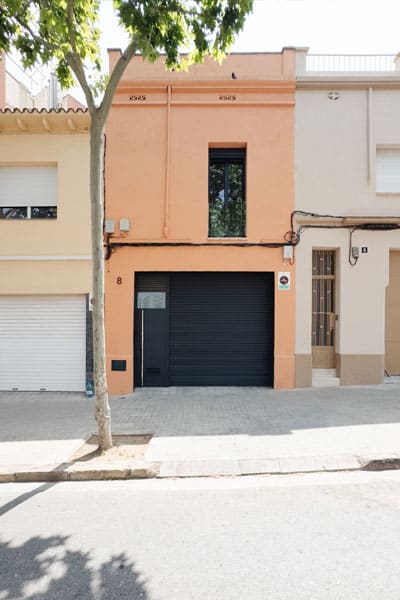 Después de fachada reformada de vivienda en Sabadell tras un proyecto de cambio de uso, con nuevo acceso y carpinterías modernas en color negro.