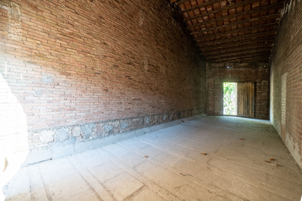Espacio original en Sabadell antes de la reforma y cambio de uso, con paredes de ladrillo visto, cubierta inclinada y sin acondicionar