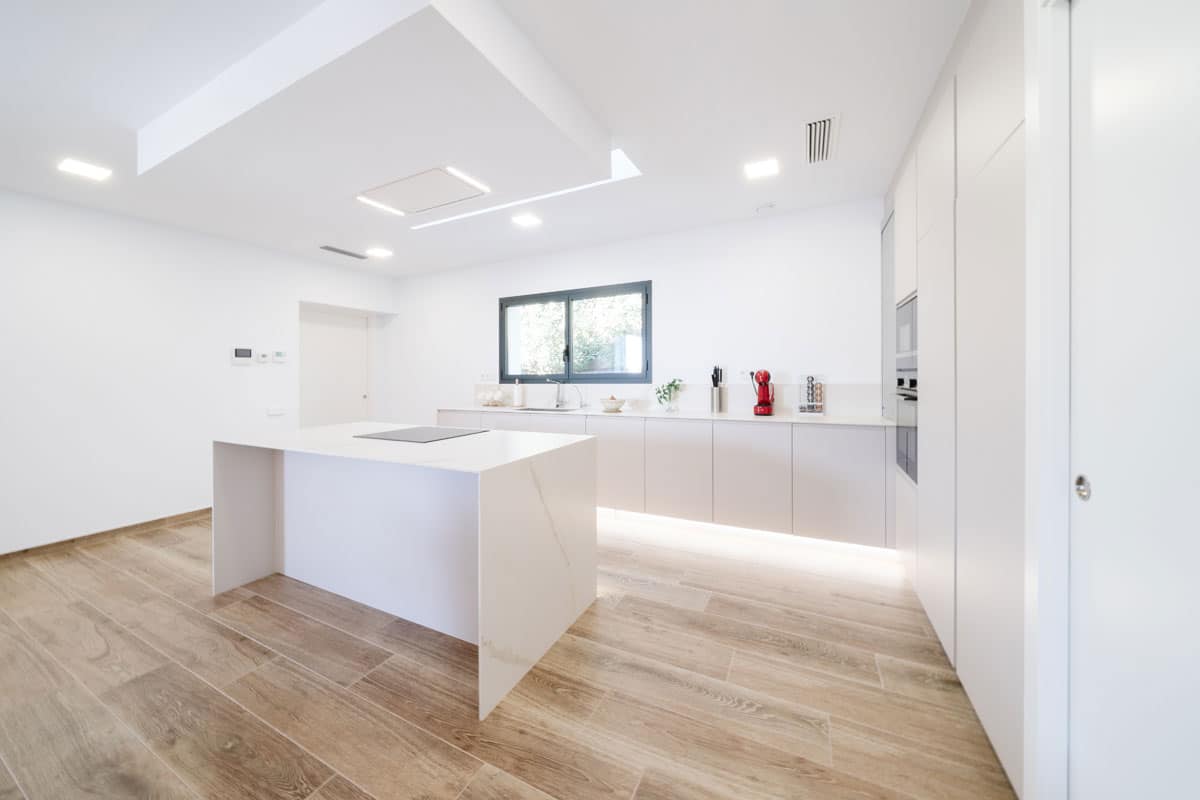 Cocina moderna y saludable en vivienda unifamiliar de l’Ametlla del Vallès, con isla central, diseño minimalista y materiales eficientes que aportan confort y bienestar.