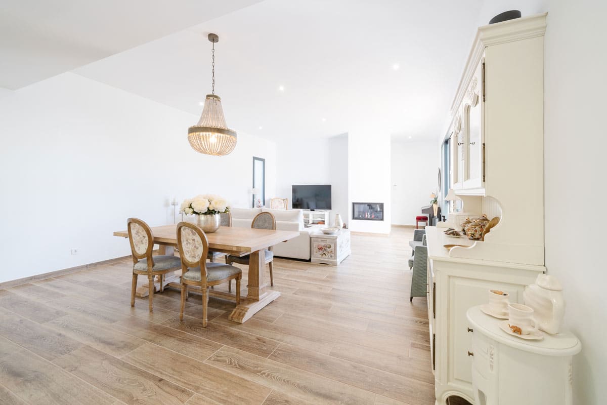 Comedor de vivienda saludable y eficiente en l’Ametlla del Vallès, con conexión directa al salón y la chimenea, diseñado para disfrutar de reuniones familiares en un espacio luminoso y confortable todo el año.