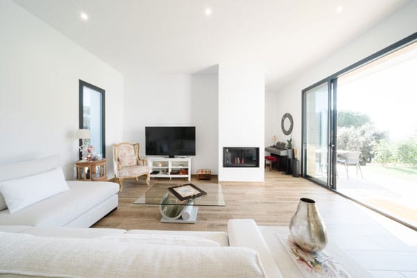 Espacio abierto de salón-comedor y cocina en casa eficiente de hormigón celular en l’Ametlla del Vallès, diseñado para un estilo de vida sano y confortable.