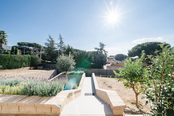 Vistas del acceso ajardinado de casa unifamiliar en l’Ametlla del Vallès, una vivienda respetuosa con el medio ambiente y pensada para el bienestar de las personas.