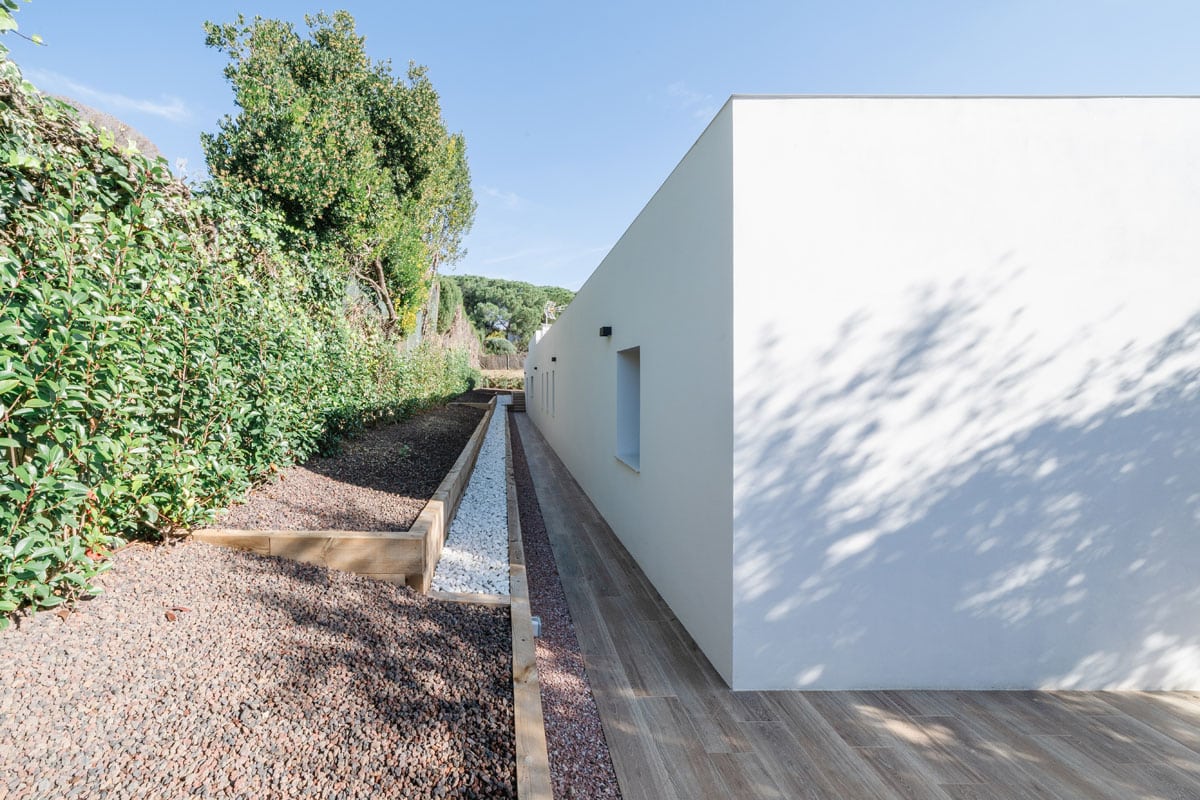 Fachada posterior de vivienda saludable y eficiente en l’Ametlla del Vallès, con diseño minimalista en hormigón celular y orientación norte destinada a pasillo y espacios de servicio, optimizando confort y sostenibilidad.