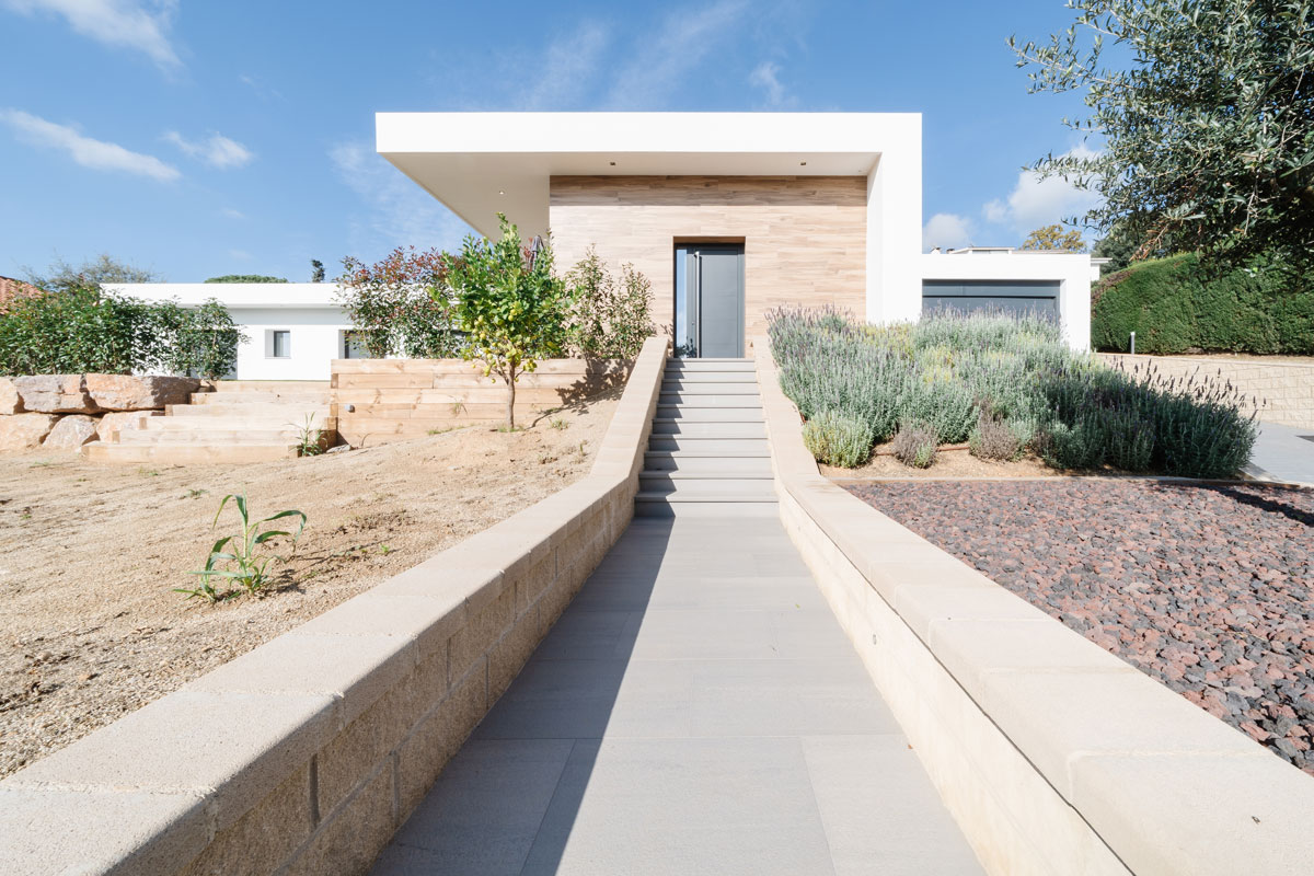 Acceso principal de casa unifamiliar en l’Ametlla del Vallès, construida con hormigón celular y líneas modernas, una vivienda sana y respetuosa con el medio ambiente.