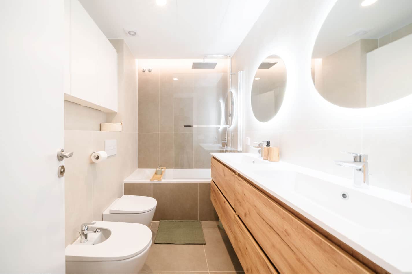 Baño reformado con mueble de madera, doble lavabo y tonos claros