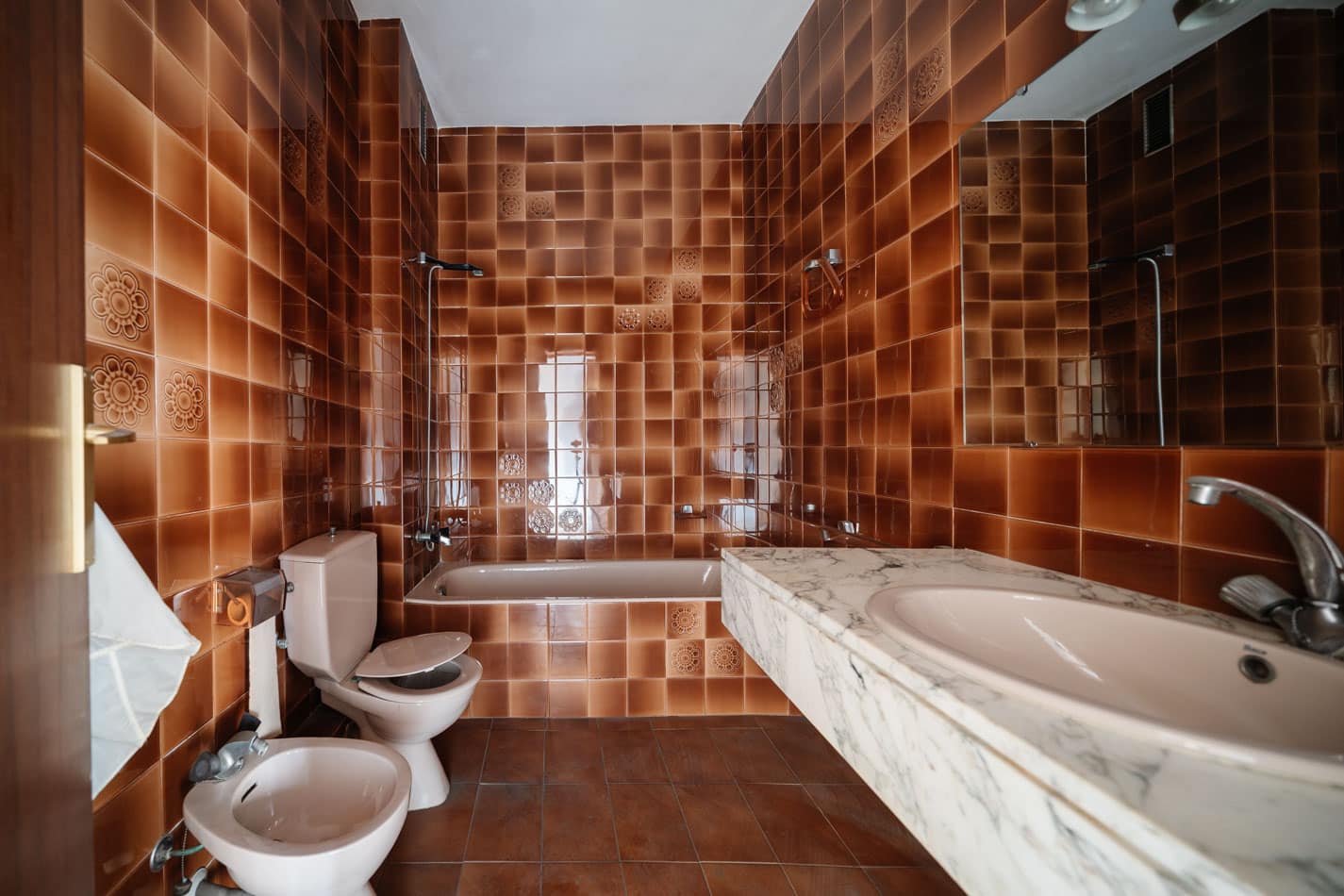 Baño original revestido con azulejo marrón antes de la reforma