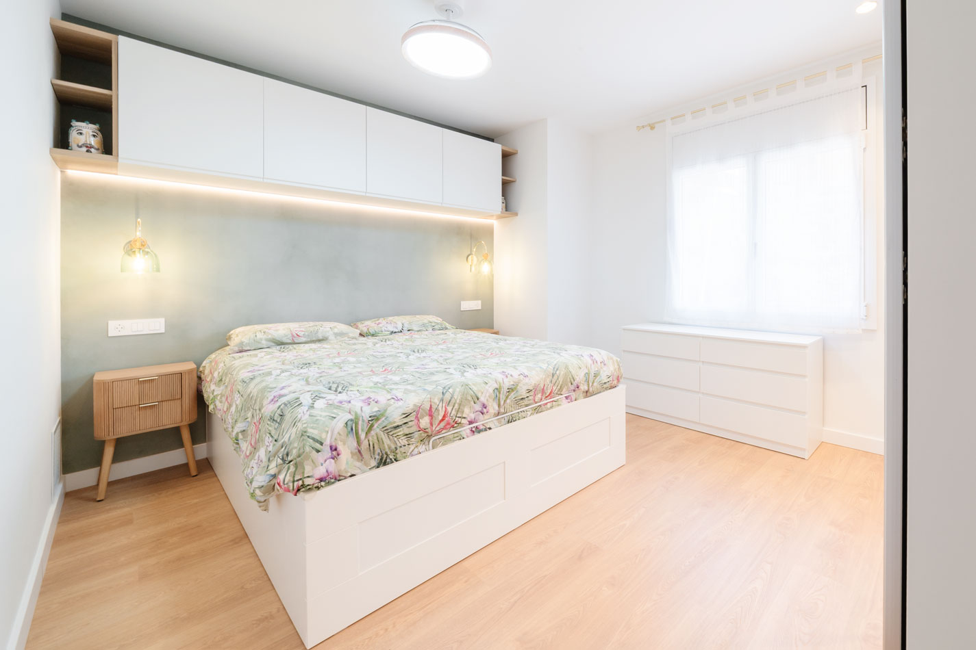 Dormitorio principal reformado con cabecero, iluminación y almacenaje superior