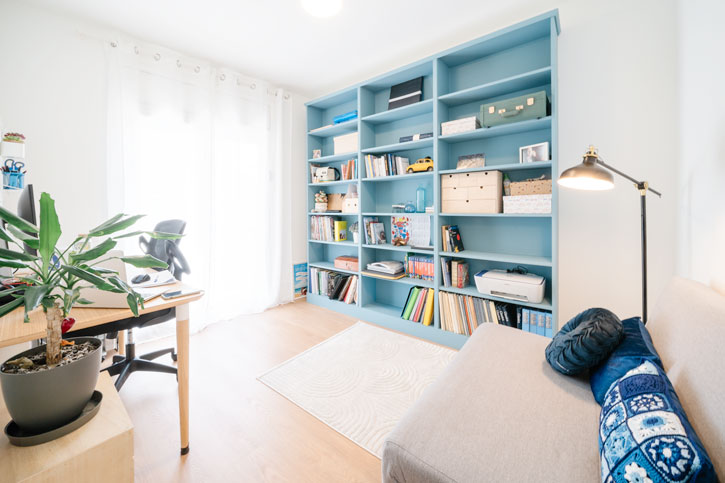 Despacho y habitación polivalente con gran librería azul