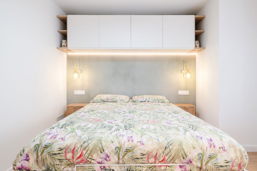 Dormitorio principal con cabecero verde e integración de armarios superiores